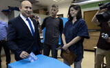 Naftali Bennett, leader of the right-wing Yamina party, and his wife Galit vote in the city of Ra'anana, Israel, Tuesday, March 23, 2021. (AP Photo/Tsafrir Abayov)