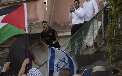 A man holding the Israeli flag shouts at protesters waving the Palestinian flag during a demonstration against the expulsion of Palestinian families from their homes in the East Jerusalem neighborhood Sheikh Jarrah, April 16, 2021. (AP Photo/Maya Alleruzzo)