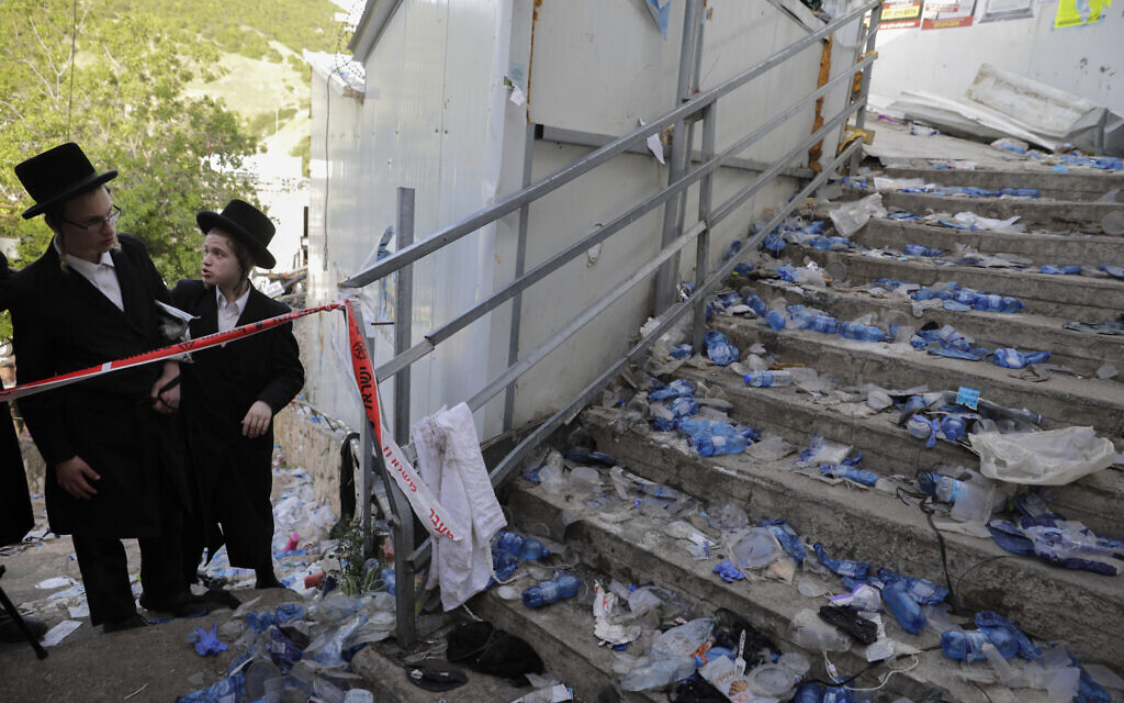 Ultra-Orthodox Jews stand at the bottom of a staircase, leading from a narrow walkway where a crush led to mass fatalities at Lag B'Omer celebrations at Mt. Meron in northern Israel, Friday, April 30, 2021. (AP Photo/Sebastian Scheiner)