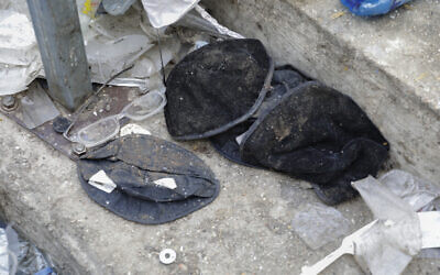 Hats and broken glasses are seen at the bottom of a stairway leading from a narrow walkway where a fatal crush occurred at the site of the Mt. Meron disaster in northern Israel, Friday, April 30, 2021 (AP Photo/Sebastian Scheiner)