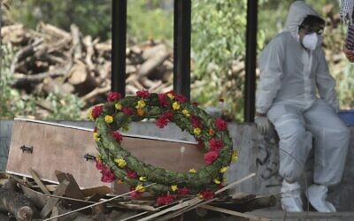 A wreath lies on the coffin of a COVID-19 victim before his cremation in Jammu, India, Friday, April 30, 2021 (AP Photo/Channi Anand)