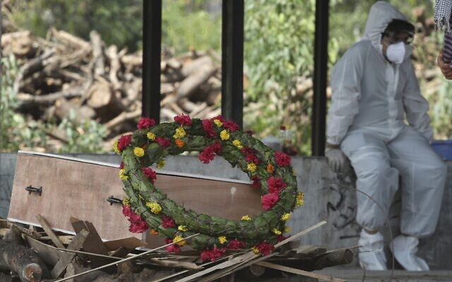 A wreath lies on the coffin of a COVID-19 victim before his cremation in Jammu, India, Friday, April 30, 2021 (AP Photo/Channi Anand) A wreath lies on the coffin of a COVID-19 victim before his cremation in Jammu, India, Friday, April 30, 2021 (AP Photo/Channi Anand)
