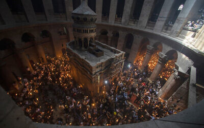 Christian pilgrims hold candles as they gather during the ceremony of the Holy Fire at Church of the Holy Sepulchre, where many Christians believe Jesus was crucified, buried and rose from the dead, in the Old City of Jerusalem, May 1, 2021. (AP Photo/Ariel Schalit)