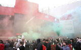 Fans make their way past barriers outside the ground as they let off flares whilst protesting against the Glazer family, owners of Manchester United, before their Premier League match against Liverpool at Old Trafford, Manchester, England, Sunday, May 2, 2021. (Barrington Coombs/PA via AP)