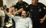 Frazier Glenn Miller Jr., convicted of capital murder, attempted murder and other charges, gestures as Johnson County deputies remove him from the courtroom during the sentencing phase of his trial at the Johnson County District Court in Olathe, Kan. November 10, 2015. (Joe Ledford/The Kansas City Star via AP, Pool, File)