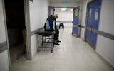 A man sits in a corridor as he waits for news of his wife who is suspected of having COVID-19 at the Dr. Norberto Raul Piacentini Hospital in Lomas de Zamora, Argentina, May 1, 2021. (AP Photo/Natacha Pisarenko)