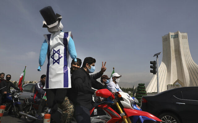 A demonstrator on a motorcycle holds an effigy representing Israel and the United States during the annual Al-Quds Day rally in Tehran, Iran, May 7, 2021  (AP Photo/Vahid Salemi)