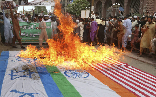 Demonstrators chant slogans after burning representations of Israeli, US and Indian flags during the annual Al-Quds, or Jerusalem, Day rally in Peshawar, Pakistan, May 7, 2021 (AP Photo/Muhammad Sajjad)