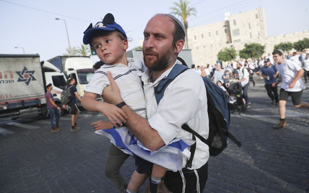 Israelis run for shelter as air attack sirens goes off during a Jerusalem Day march, in Jerusalem, Monday, May 10, 2021. (AP/Ariel Schalit)