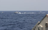 In this image provided by the US Navy, an Iranian Islamic Revolutionary Guard Corps Navy fast in-shore attack craft, a type of speedboat armed with machine guns, speeds near US naval vessels transiting the Strait of Hormuz, on May 10, 2021. (US Navy via AP)
