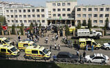 Ambulances, police cars and a truck are parked at a school after a shooting in Kazan, Russia, May 11, 2021. (AP Photo/Roman Kruchinin)