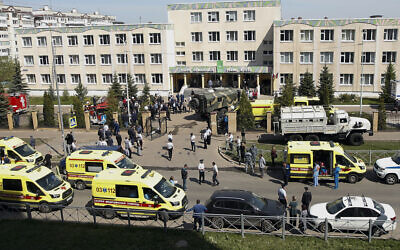 Ambulances, police cars and a truck are parked at a school after a shooting in Kazan, Russia, May 11, 2021. (AP Photo/Roman Kruchinin)