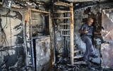Avi Korkas examines the damage to a municipality office that was torched in a night of violence between Arab Israeli protesters and Israel Police in the city of Lod, May 11, 2021. (AP Photo/Heidi Levine)