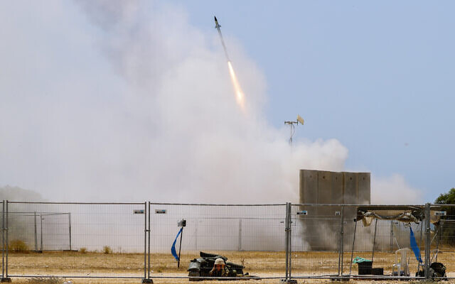 A Israeli soldier takes cover as an Iron Dome air defense system launches to intercept a rocket from the Gaza Strip, in southern Israel, May 11, 2021. (AP Photo/Ariel Schalit) A Israeli soldier takes cover as an Iron Dome air defense system launches to intercept a rocket from the Gaza Strip, in southern Israel, May 11, 2021. (AP Photo/Ariel Schalit)