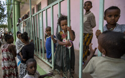 Children displaced by the conflict play on metal railings at the elementary school where they now live with their families in the town of Abi Adi, in the Tigray region of northern Ethiopia Tuesday, May 11, 2021. (AP Photo/Ben Curtis)