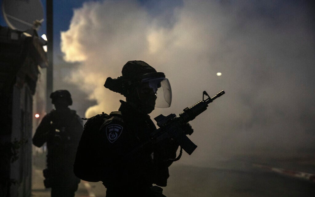 Israeli forces run during clashes with Arab Israelis in the Israeli mixed city of Lod, Israel, Tuesday, May 11,2021. (AP Photo/Heidi Levine)