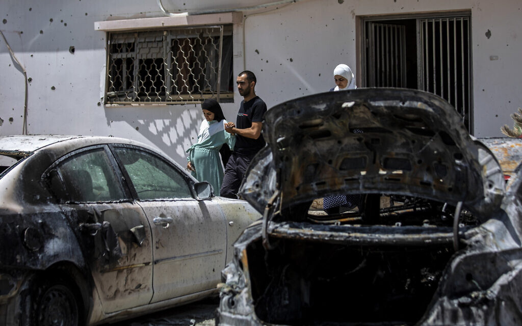 Relatives walk out of the damaged home of Nadine, 16, and Khalil Awaad, a father and daughter who were killed by a rocket fired from the Gaza Strip, in their village of Dahmash, May 12, 2021. (AP Photos/Heidi Levine)