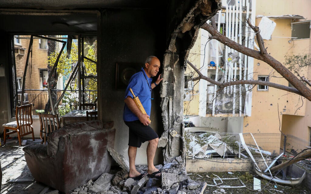 A member of Sror family inspect the damage of their apartment after being hit by a rocket fired from the Gaza Strip over night, in Petah Tikva, central Israel, May 13, 2021. (AP Photo/Oded Balilty)