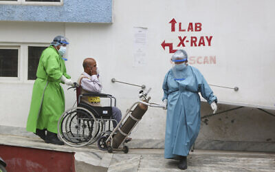 Paramedics take a COVID-19 patient to a ward after doing an X-ray at a government-run hospital in Kathmandu, Nepal, May 12, 2021. (AP Photo/Niranjan Shrestha)