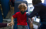 A boy holds his mother's hand as he receives the Pfizer COVID-19 vaccine. (AP Photo/Jae C. Hong)