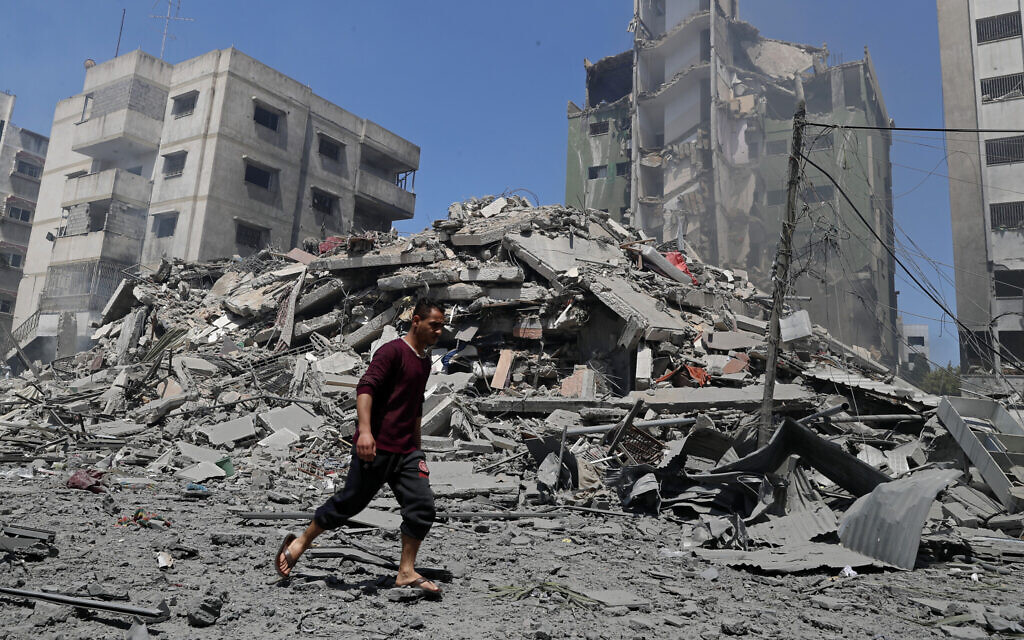 A man walks past the the rubble of the Yazegi residential building that was destroyed by an Israeli airstrike, in Gaza City, Sunday, May 16, 2021. (AP Photo/Adel Hana) A man walks past the the rubble of the Yazegi residential building that was destroyed by an Israeli airstrike, in Gaza City, Sunday, May 16, 2021. (AP Photo/Adel Hana)