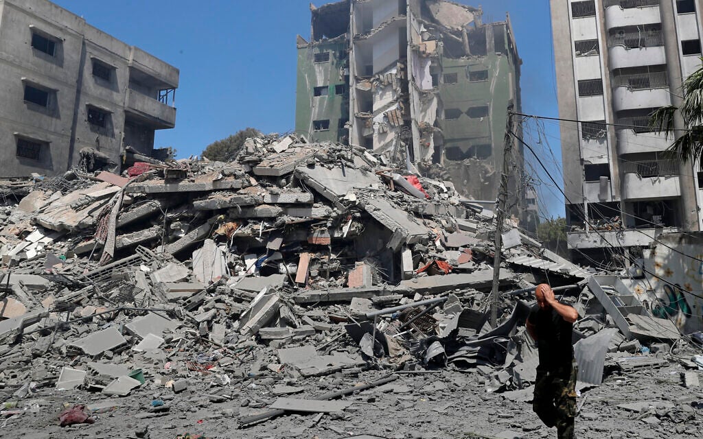 A man reacts while walking past the the rubble of the Yazegi residential building that was destroyed by an Israeli airstrike, in Gaza City, Sunday, May 16, 2021. (AP/Adel Hana)