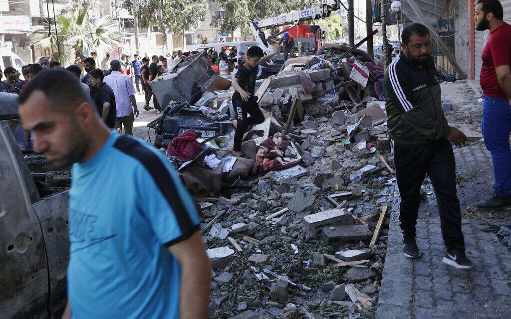 People inspect rubble of a destroyed building that was hit by an Israeli airstrike early morning, in Gaza City, Wednesday, May 19, 2021. (AP Photo/Adel Hana)