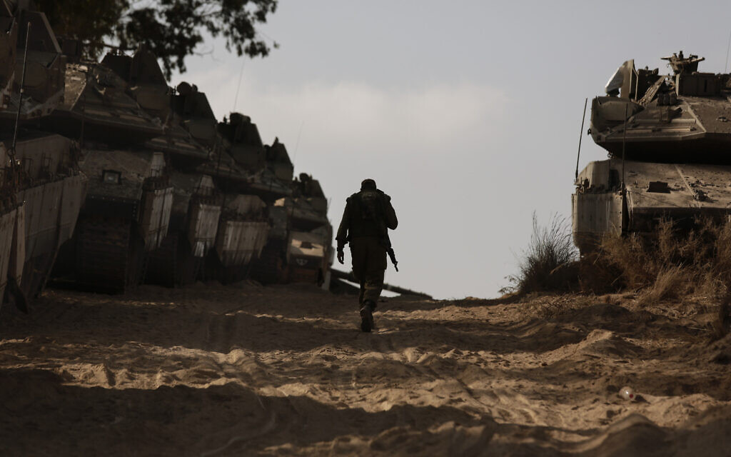 An Israeli soldier walks at a staging ground near the border with the Gaza Strip, in southern Israel, May 20, 2021. (AP Photo/Maya Alleruzzo)
