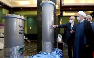 Iranian President Hassan Rouhani, second right, listens to head of the Atomic Energy Organization of Iran Ali Akbar Salehi while visiting an exhibition of Iran's new nuclear achievements in Tehran, Iran, April 10, 2021. (Iranian Presidency Office via AP)
