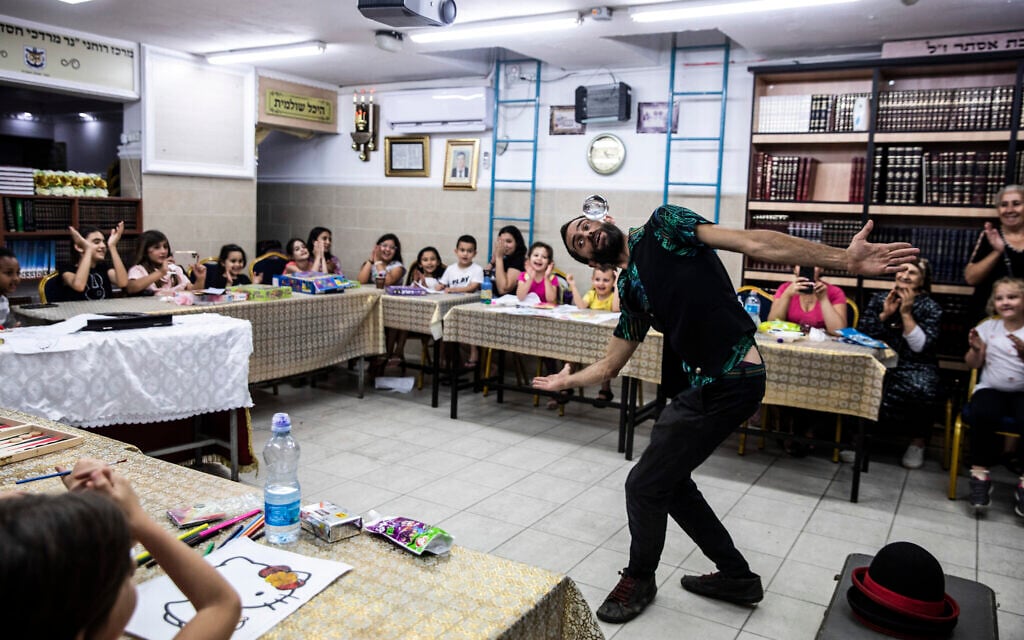 Israeli juggler Guy Kaplan performs for children in a bomb shelter, following rocket attacks fired from the Gaza Strip, in Ashdod, Israel,  May 20, 2021. (AP Photo/Heidi Levine)