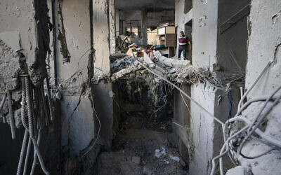 People enter the severely damaged Al-Jawhara building to salvage valuable items following a cease-fire reached after an 11-day war between Gaza's Hamas rulers and Israel, in Gaza City, Friday, May 21, 2021. (AP Photo/John Minchillo)
