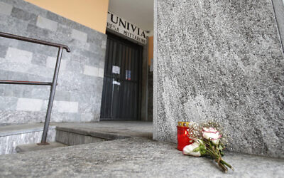 Flowers and a candle lie in front of the Stresa to Mottarone cable car departure station, in Stresa, northern Italy, May 24, 2021. (Antonio Calanni/AP)