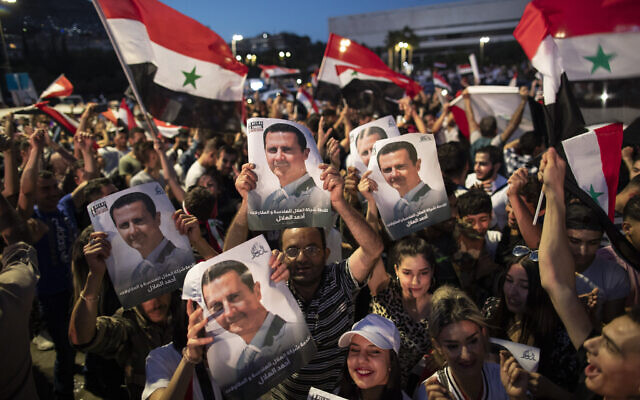 Syrian President Bashar Assad supporters hold up national flags and pictures of Assad as they celebrate at Omayyad Square, in Damascus, Syria on May 27, 2021. (AP Photo/Hassan Ammar) Syrian President Bashar Assad supporters hold up national flags and pictures of Assad as they celebrate at Omayyad Square, in Damascus, Syria on May 27, 2021. (AP Photo/Hassan Ammar)
