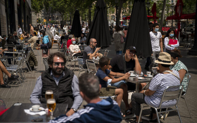 Customers sit in a terrace bar in downtown Barcelona, Spain, May 28, 2021. (AP Photo/Emilio Morenatti, File) Customers sit in a terrace bar in downtown Barcelona, Spain, May 28, 2021. (AP Photo/Emilio Morenatti, File)