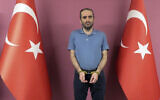 Selahaddin Gulen, a nephew of US-based Muslim cleric Fethullah Gulen, stands between Turkish flags in this photo provided by Turkish intelligence service, on May 31, 2021, in Ankara, Turkey. (Turkish Intelligence Service via AP)