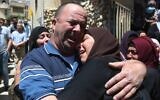 Bereaved relations of Ahmad Daraghme, an officer in the Palestinian Authority intelligence services killed by Israeli soldiers, weep at his funeral in his home village of Laban al-Sharqiya on Wednesday, May 12, 2021 (WAFA)