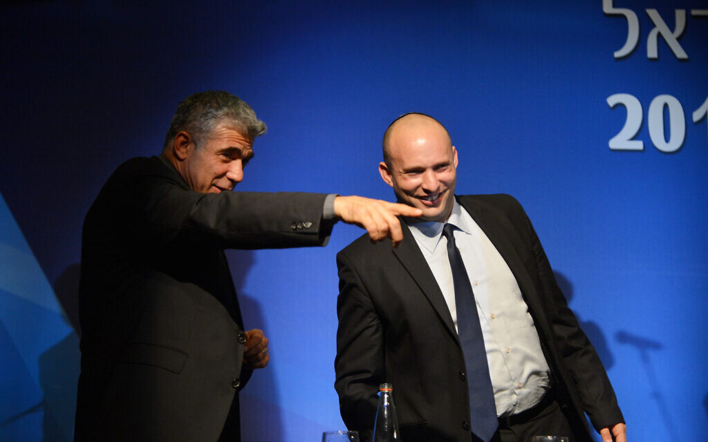 File: Then-finance minister Yair Lapid (left) and then-economy minister Naftali Bennett at the Manufacturers Association of Israel annual general assembly at the David Intercontinental Hotel in Tel Aviv, February 26, 2014. (Yossi Zeliger/Flash 90.) File: Then-finance minister Yair Lapid (left) and then-economy minister Naftali Bennett at the Manufacturers Association of Israel annual general assembly at the David Intercontinental Hotel in Tel Aviv, February 26, 2014. (Yossi Zeliger/Flash 90.)