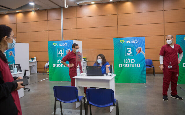 Medical workers at a vaccination center, in Tel Aviv. March 8, 2021. (Miriam Alster/ Flash90)