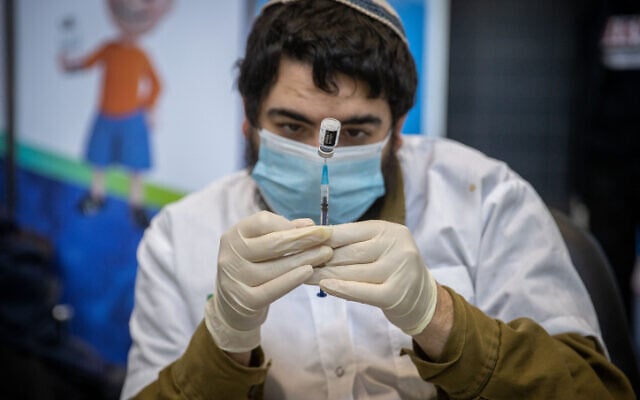 A medical worker prepares a COVID-19 vaccine injection, at a Clalit vaccination center in Jerusalem, on March 8, 2021. (Yonatan Sindel/Flash90) A medical worker prepares a COVID-19 vaccine injection, at a Clalit vaccination center in Jerusalem, on March 8, 2021. (Yonatan Sindel/Flash90)