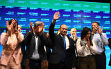 Yamina chair Naftali Bennett (C) and party members seen with supporters at a party event in Petah Tikva after election day, March 23, 2021. (Avi Dishi/Flash90)