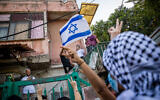 Palestinians and left-wing activists protest against the expulsion of Palestinian families from their homes in the East Jerusalem neighborhood Sheikh Jarrah, April 16, 2021. (Yonatan Sindel/Flash90)