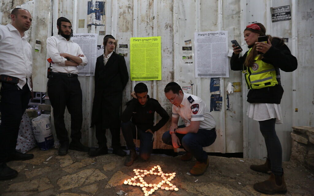 Ultra-Orthodox Jews light candles for the 45 victims of the deadly crush during Lag B'Omer celebrations at Mount Meron, at the scene of the fatal disaster. May 1, 2021. (David Cohen/Flash90)