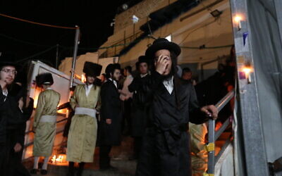 Ultra-Orthodox Jews light candles and mourn for the 45 victims of the deadly crush during Lag B'Omer celebrations at Mount Meron, at the scene of the fatal disaster. May 1, 2021. (David Cohen/Flash90)
