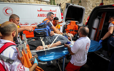 Palestinians evacuate a wounded protester during clashes with Israeli security forces in Jerusalem's Old City on Jerusalem Day, May 10, 2021. Photo by Olivier Fitoussi/Flash90