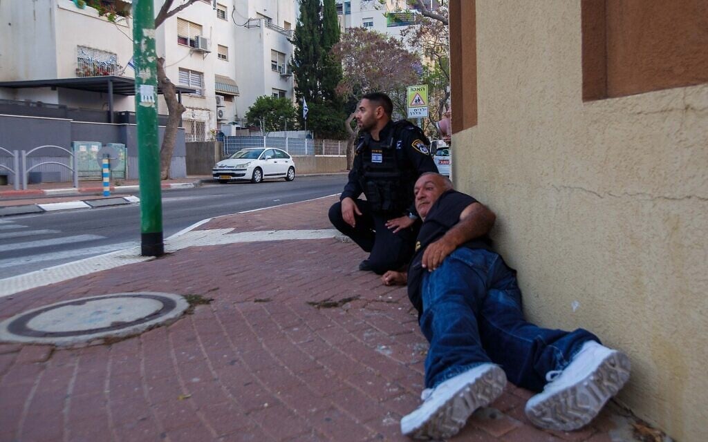 People shelter during a rocket siren in Ashkelon on May 11, 2021 (Edi Israel/Flash90)