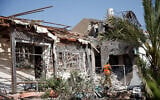 Israeli security forces at the scene where a rocket fired from the Gaza Strip hit a house in the southern Israeli city of Ashkelon, on May 11, 2021. (Flash90)