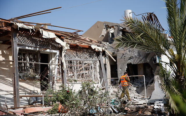 Israeli security forces at the scene where a rocket fired from the Gaza Strip hit a house in the southern Israeli city of Ashkelon, on May 11, 2021. (Flash90) Israeli security forces at the scene where a rocket fired from the Gaza Strip hit a house in the southern Israeli city of Ashkelon, on May 11, 2021. (Flash90)