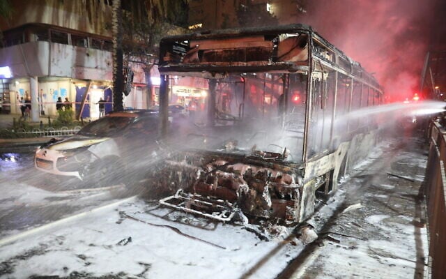 The shell of a bus which was directly hit by a rocket fired from the Gaza Strip, in Holon, central Israel, injuring several people, on May 11, 2021. (Noam Revkin Fenton/Flash90 ) The shell of a bus which was directly hit by a rocket fired from the Gaza Strip, in Holon, central Israel, injuring several people, on May 11, 2021. (Noam Revkin Fenton/Flash90 )
