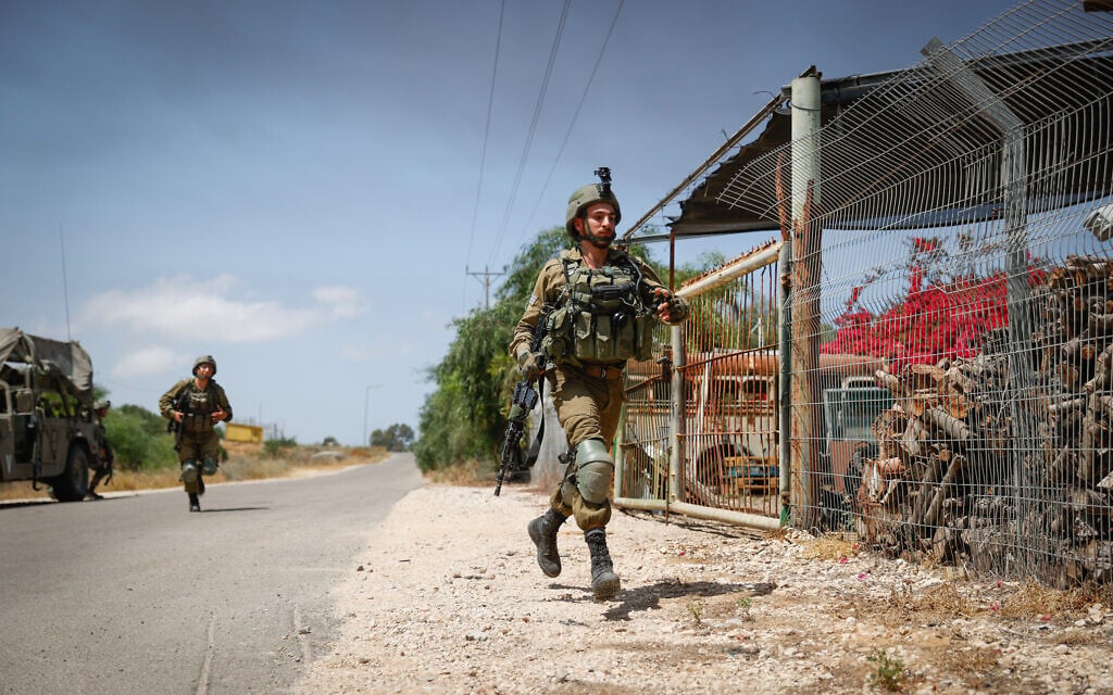Israeli soldiers near the site of where a jeep was hit by an anti-tank missile fired from Gaza, May 12, 2021 (Yonatan Sindel/Flash90)