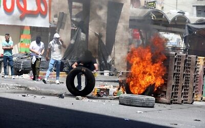 Palestinian protesters clash with Israeli security forces in the West Bank city of Hebron, May 14, 2021. (Wisam Hashlamoun/Flash90)